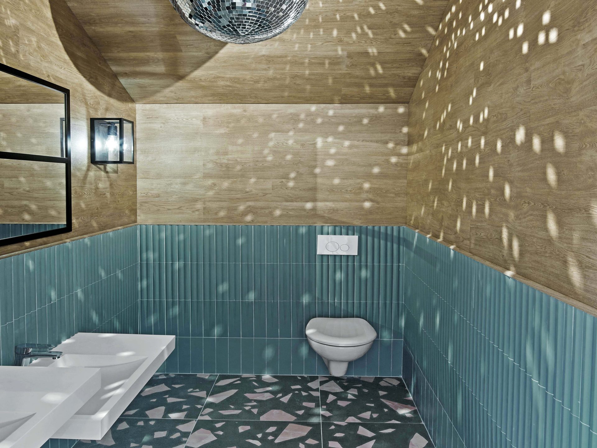 Sanitaires avec boule à facettes et carrelage cannelé bleu
