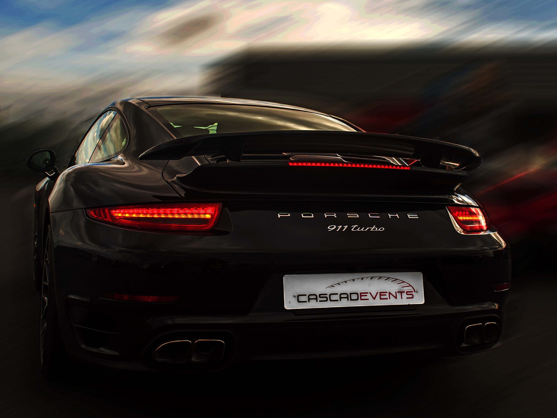 Cascadevents — séquence Porsche 911 Turbo 1/3, vue arrière complète aileron déployé, plaque Cascadevents bien lisible