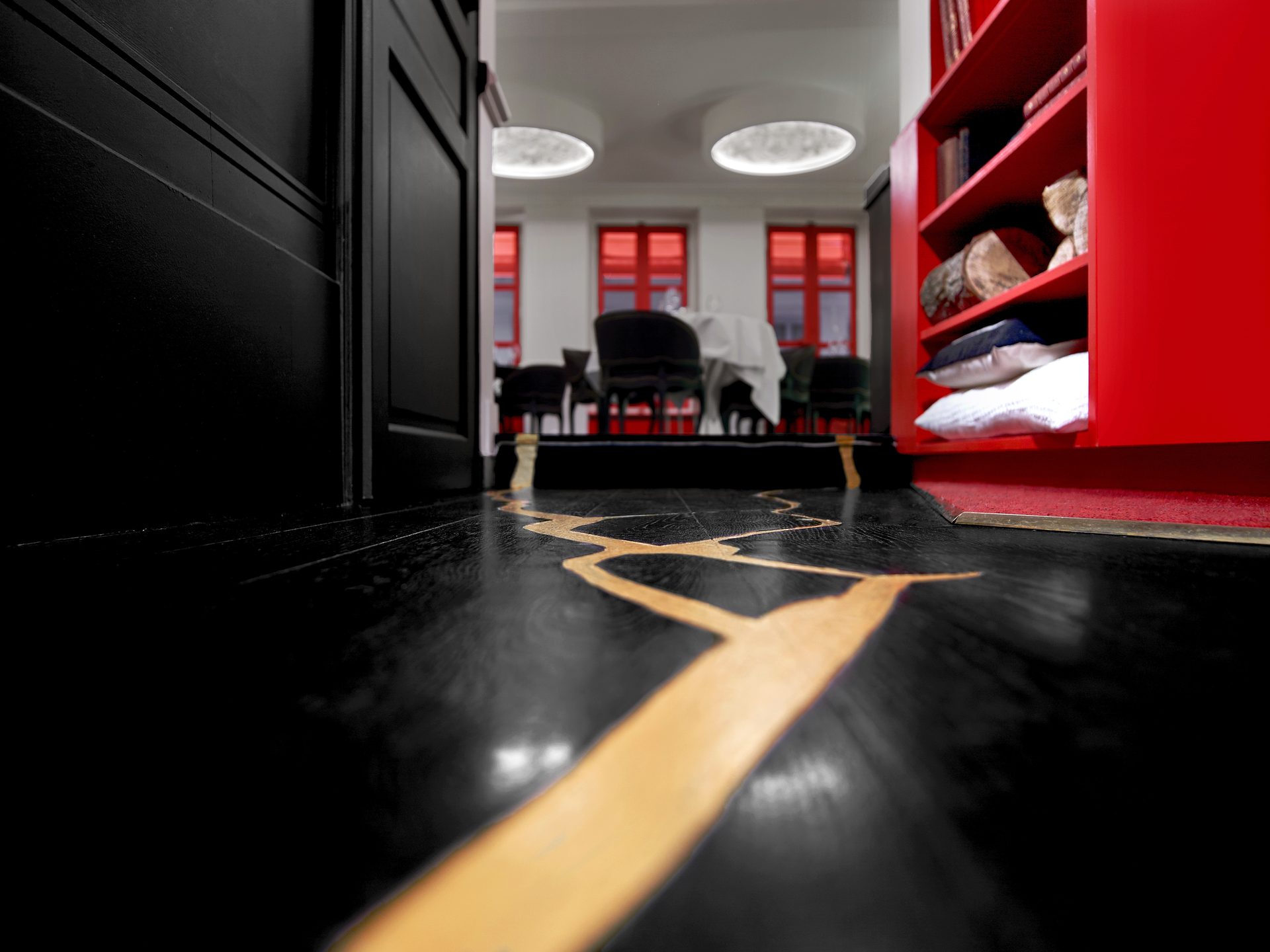 Boutary — vue 21 — sol parquet noir traversé d'une coulure kintsugi dorée, perspective vers salle blanche