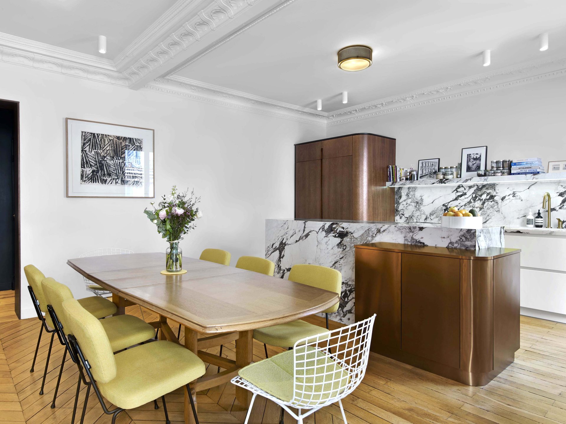 Salle à manger avec table en bois, chaises moutarde et bloc marbre veiné