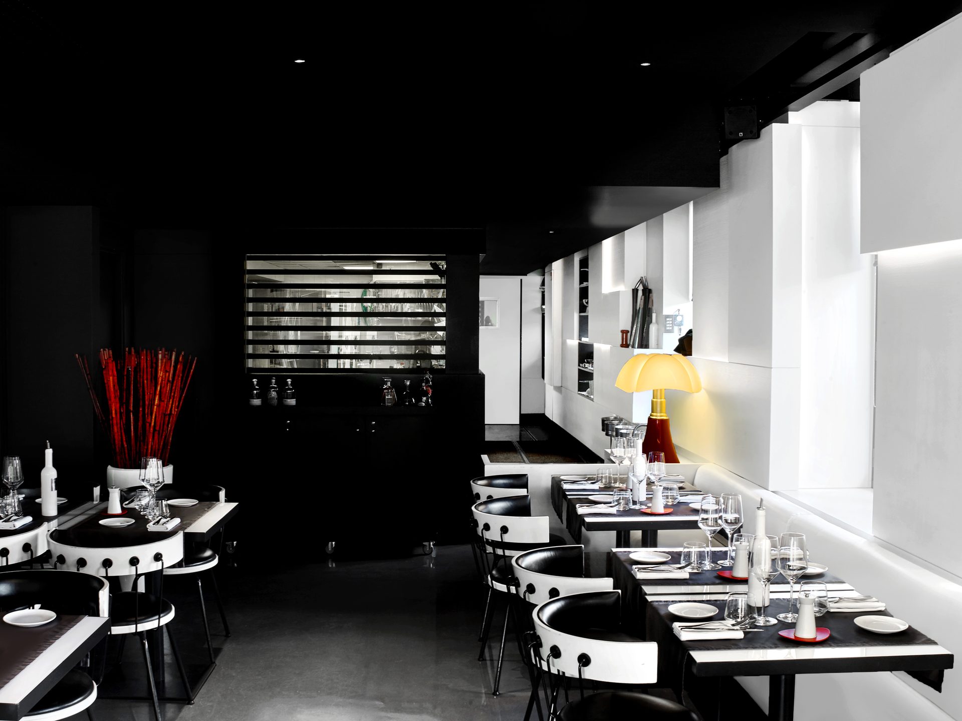 Nolita Paris — vue 19 — salle du bar côté nuit, plafond noir et courbe dorée signature 500 & Riva, bambous rouges et lampe Pipistrello jaune de Gae Aulenti