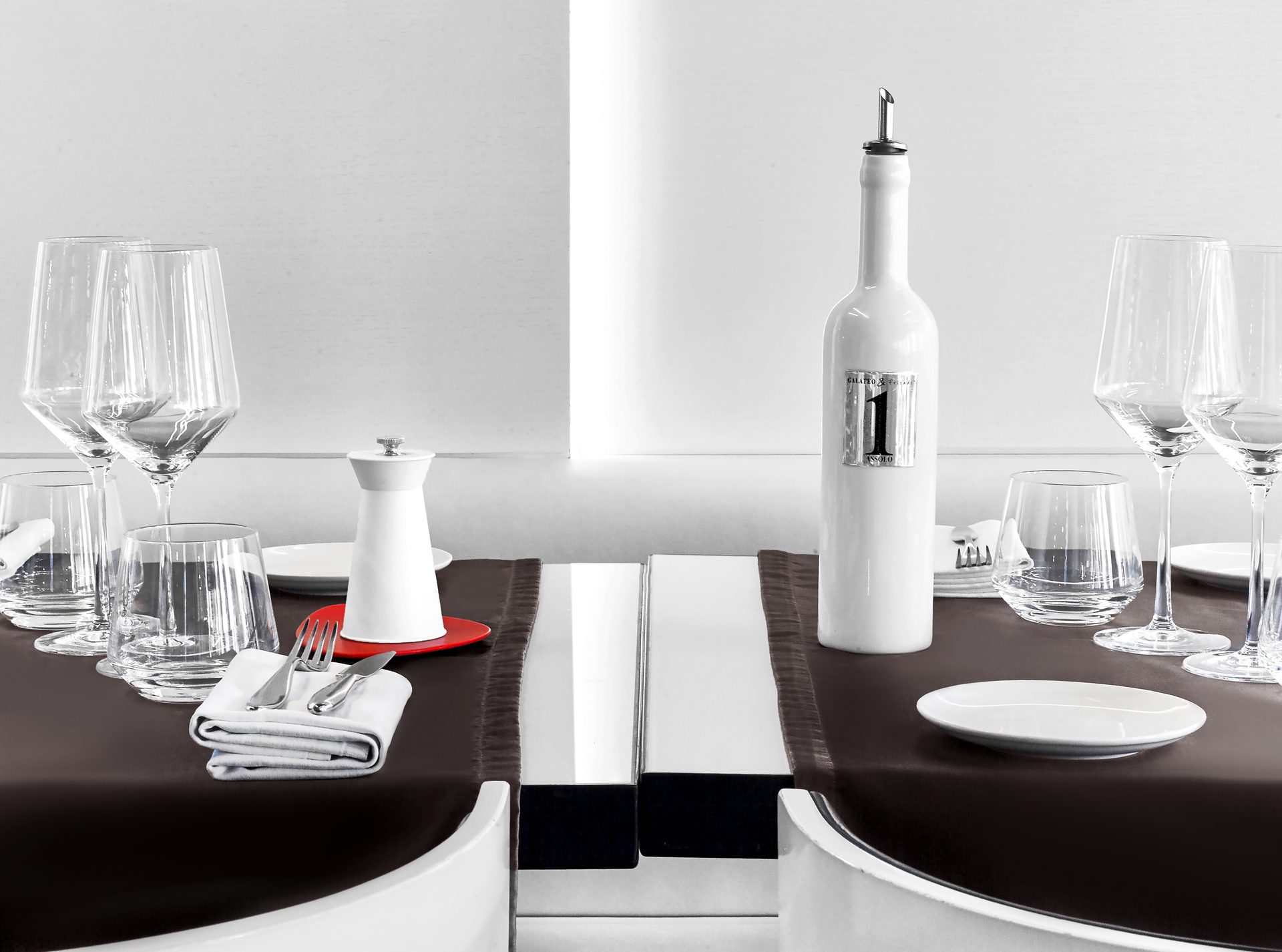 Nolita Paris — vue 24 — détail nature morte avec bouteille d'huile Assolo blanche, signal rouge du dessous-de-plat, parois blanches Wilmotte en gradins éclairées