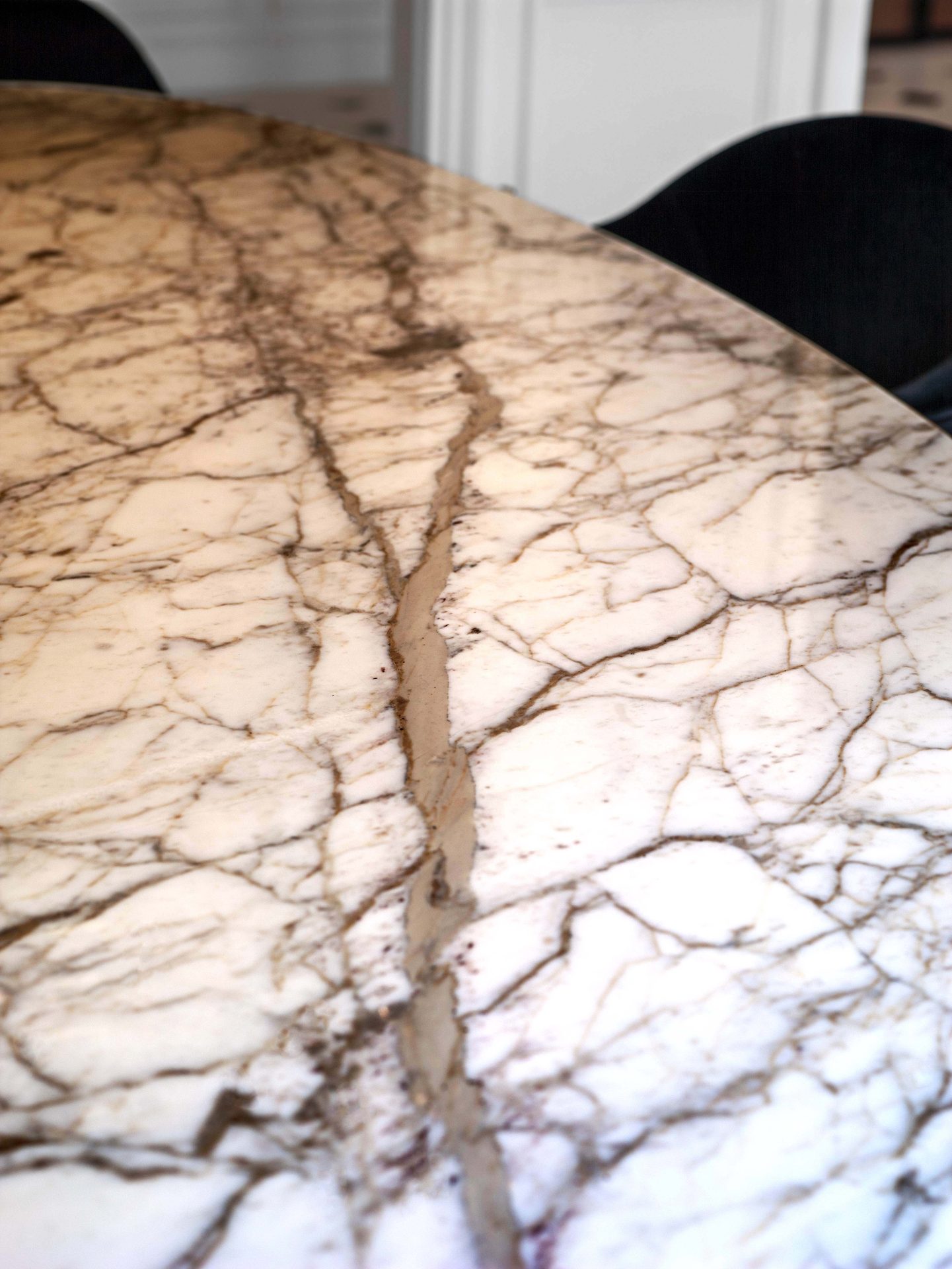 Appartement au Trocadéro — vue 06 — détail du plateau de table en marbre veiné, veines brun-doré sur fond blanc