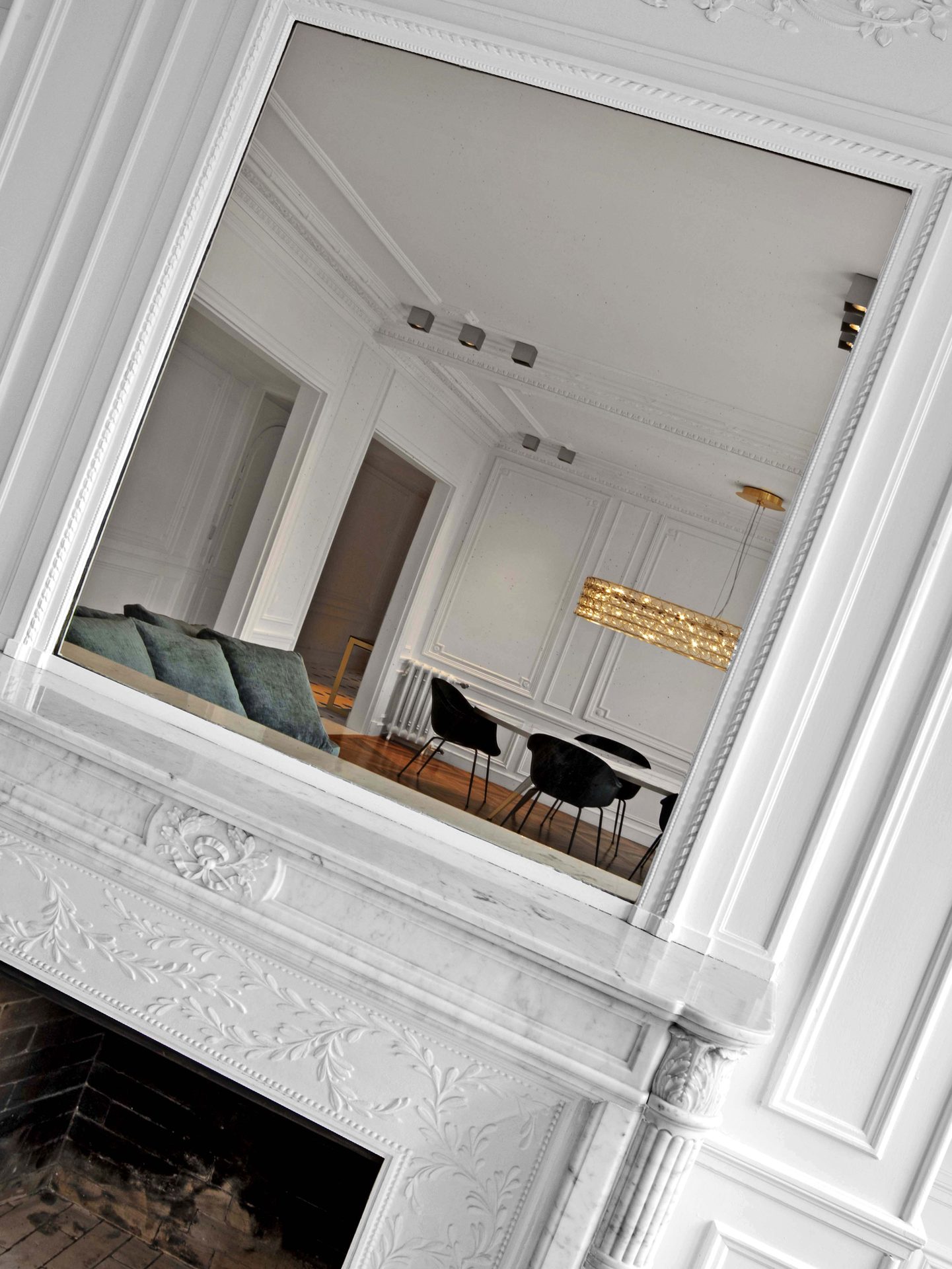Appartement au Trocadéro — vue 10 — reflet dans un miroir mural : salon, suspension dorée et boiseries moulurées