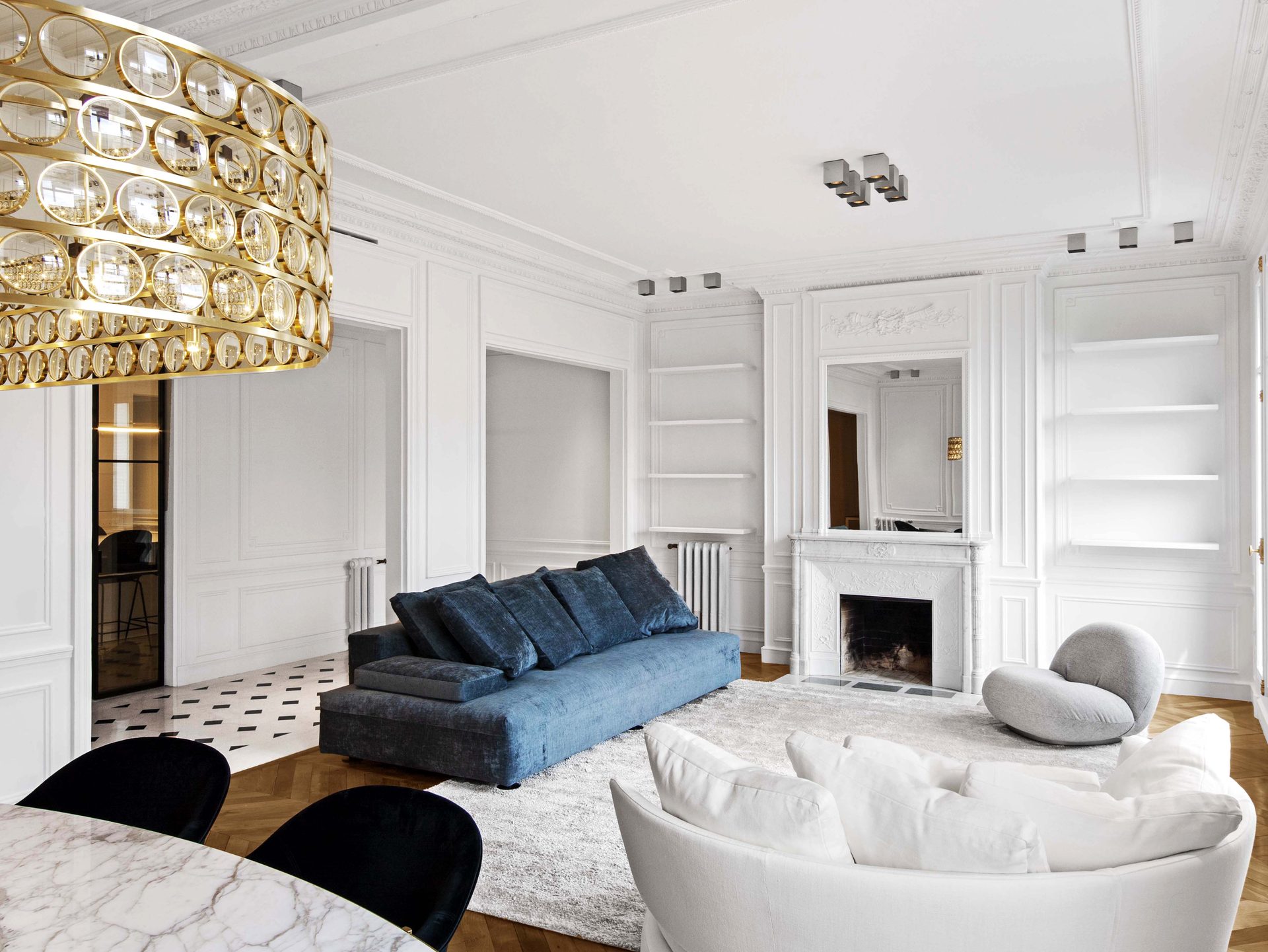 Appartement au Trocadéro — vue 12 — vue d'ensemble du séjour, canapés bleu et blanc, cheminée de marbre, lustre annulaire laiton