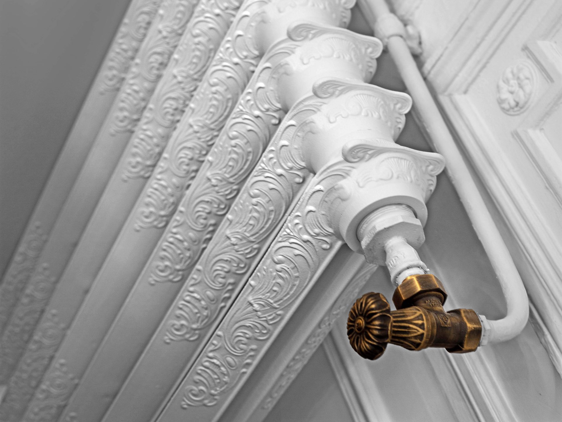Appartement au Trocadéro — vue 14 — détail de radiateur en fonte à motifs, robinet thermostatique en laiton patiné