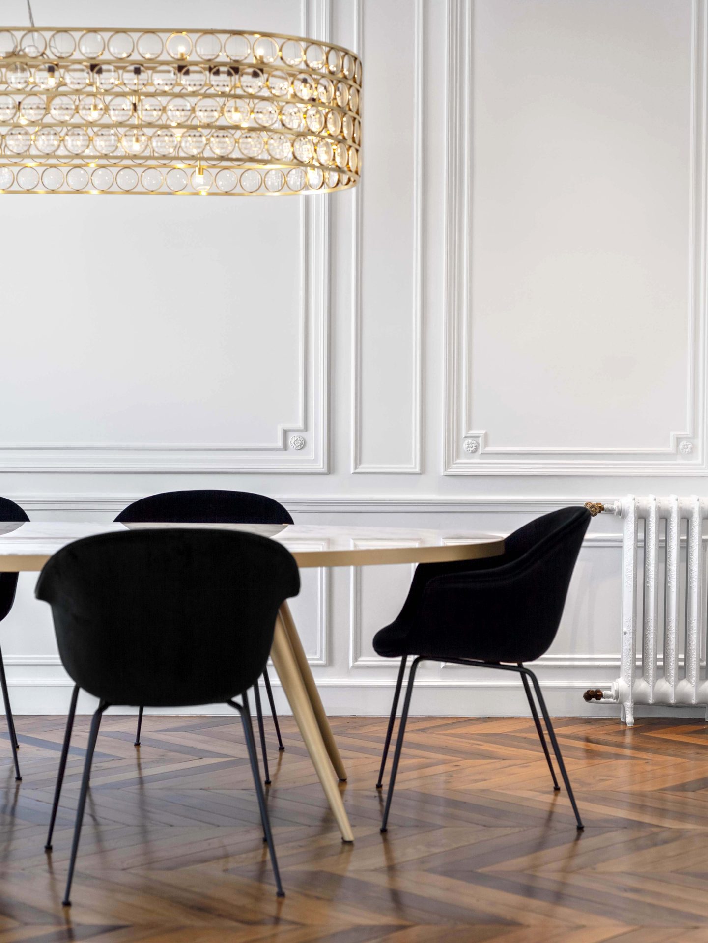 Appartement au Trocadéro — vue 15 — salle à manger, chaises velours noir et table marbre, radiateur fonte ancien sous moulures
