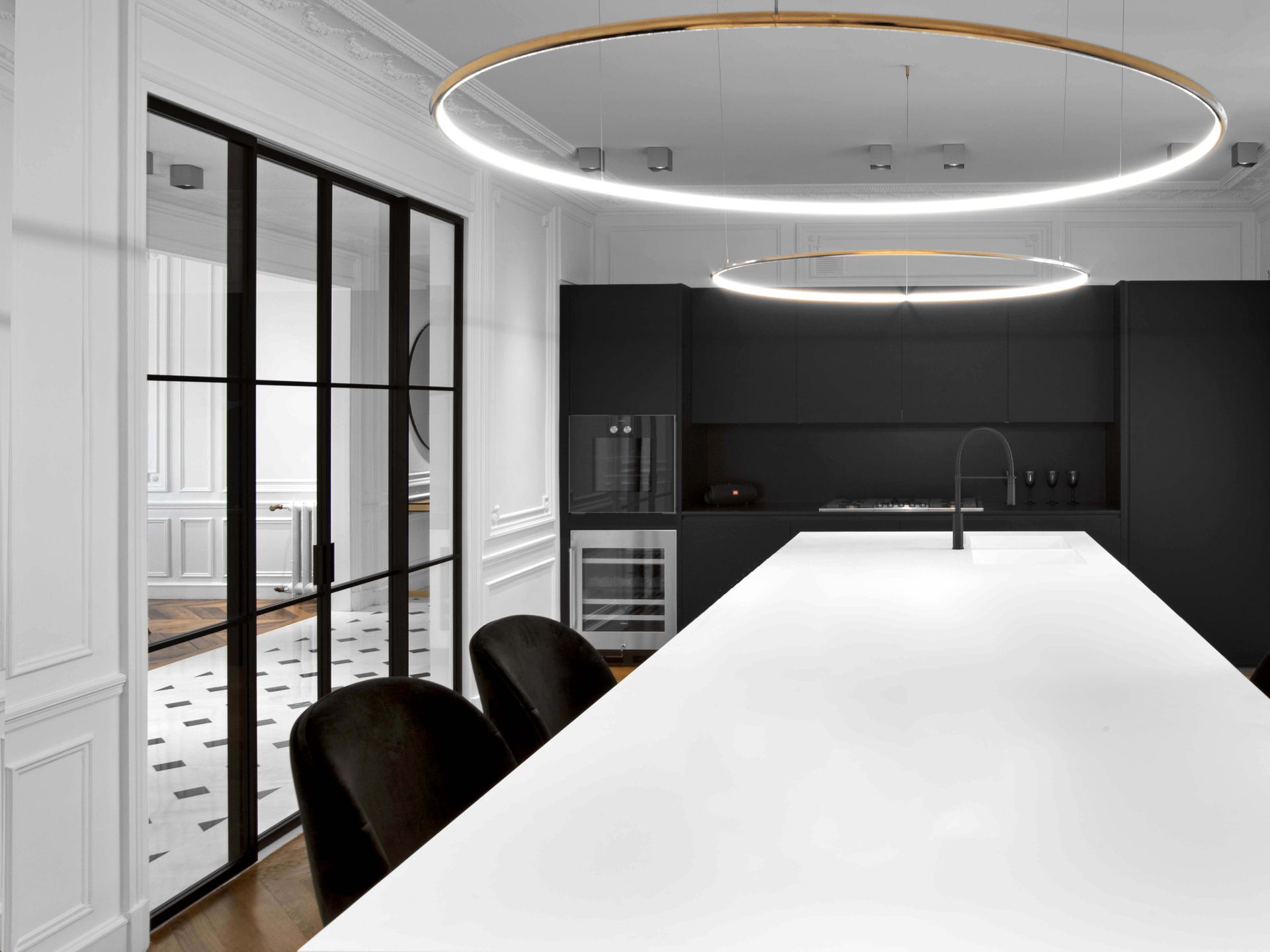 Appartement au Trocadéro — vue 18 — cuisine noire et îlot laqué blanc, anneaux lumineux, cave à vin intégrée