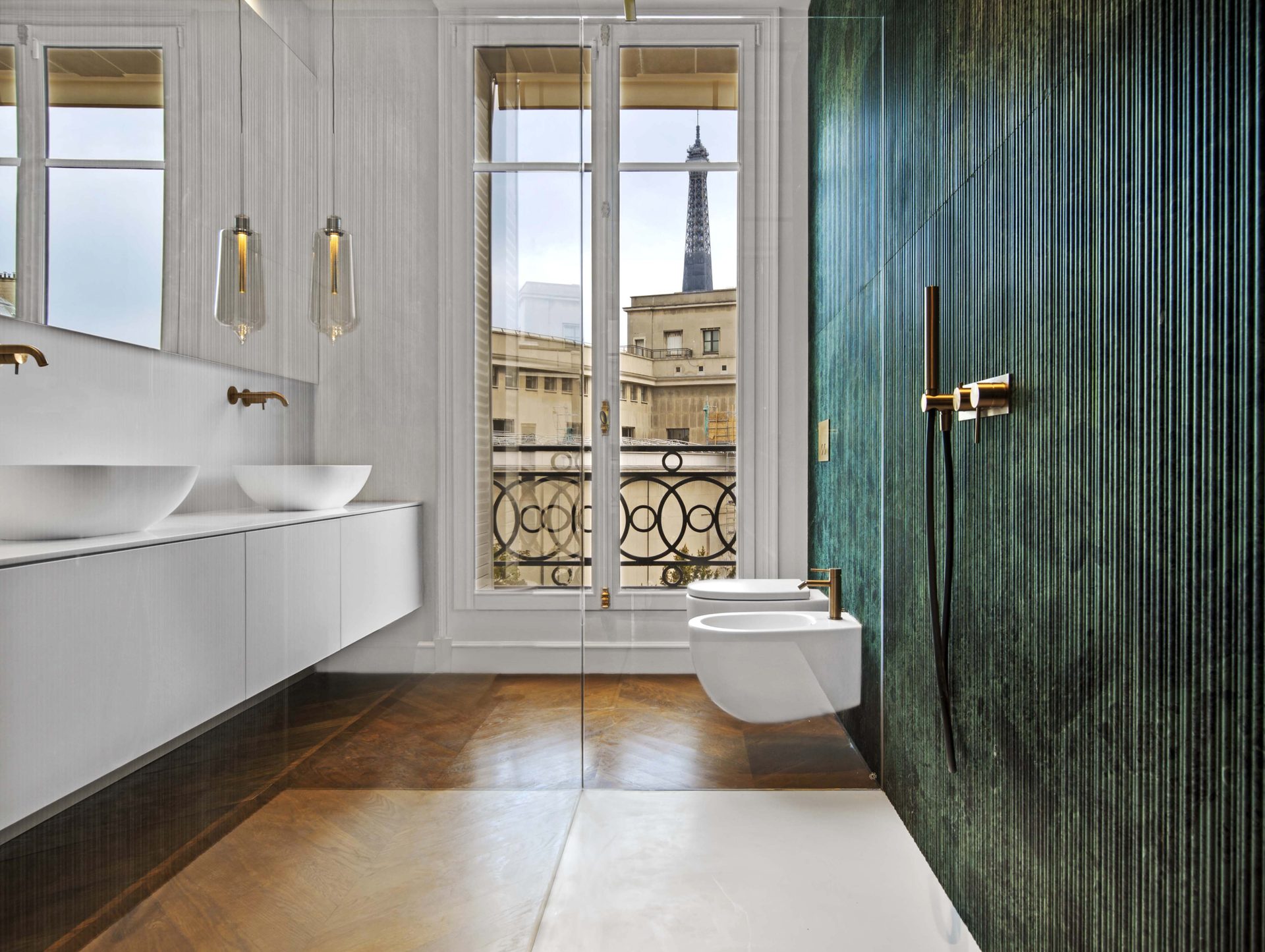 Appartement au Trocadéro — vue 20 — salle de bains, double vasque, paroi en pierre verte veinée, vue sur la tour Eiffel par la fenêtre