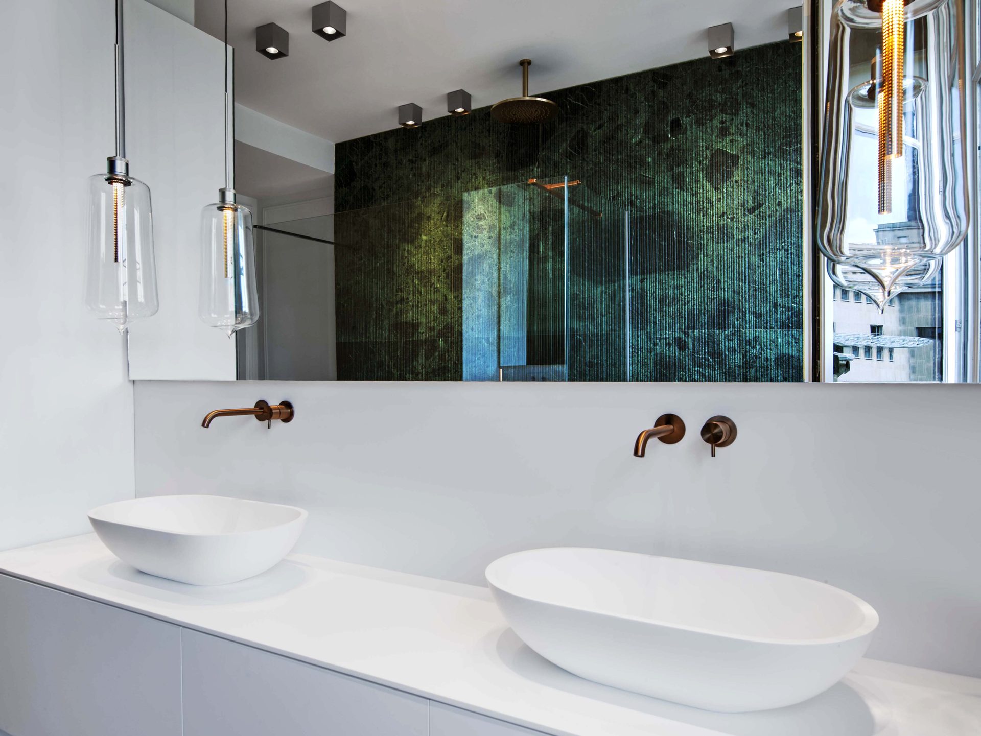 Appartement au Trocadéro — vue 22 — salle de bains, double vasque blanche, robinetterie cuivre, paroi de marbre vert et suspensions de verre