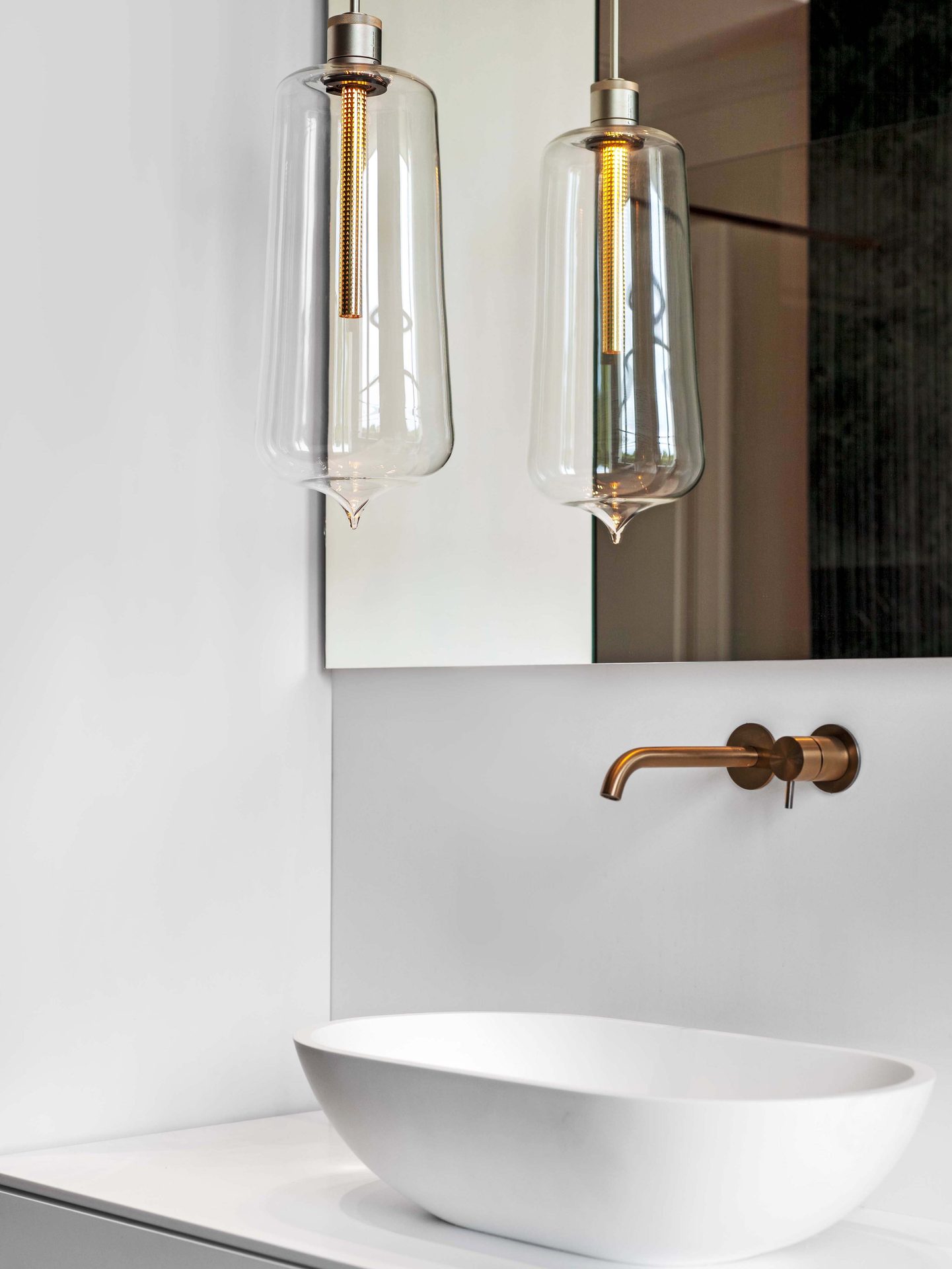 Appartement au Trocadéro — vue 24 — vasque blanche et suspensions de verre soufflé à filament, mitigeur mural cuivre, miroir