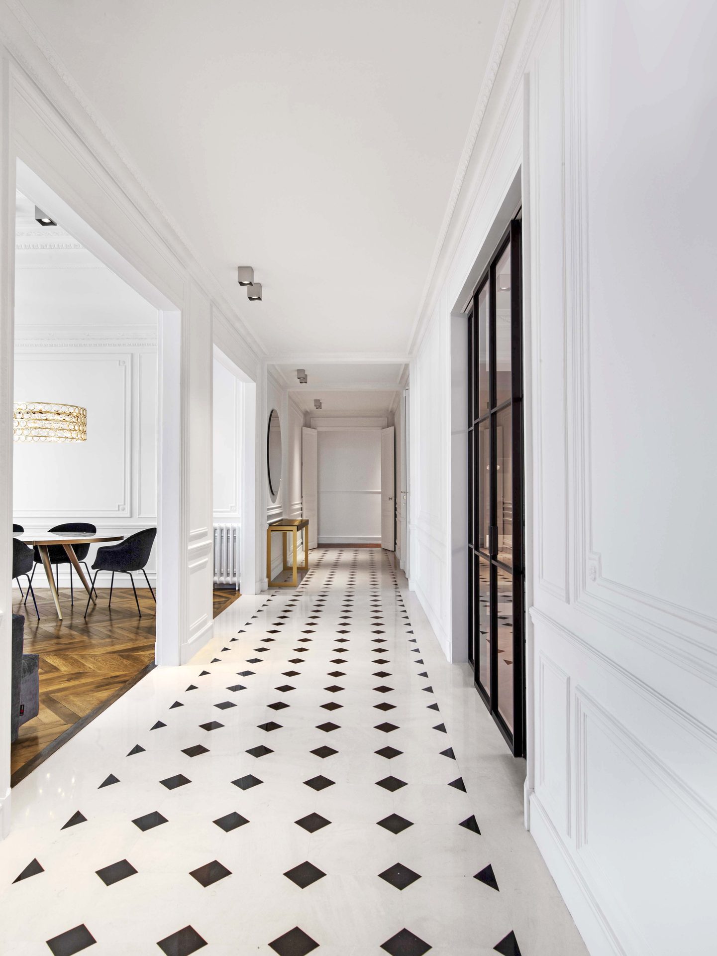Appartement au Trocadéro — vue 34 — galerie haussmannienne, sol damier marbre noir et blanc, console laiton, verrière atelier noire