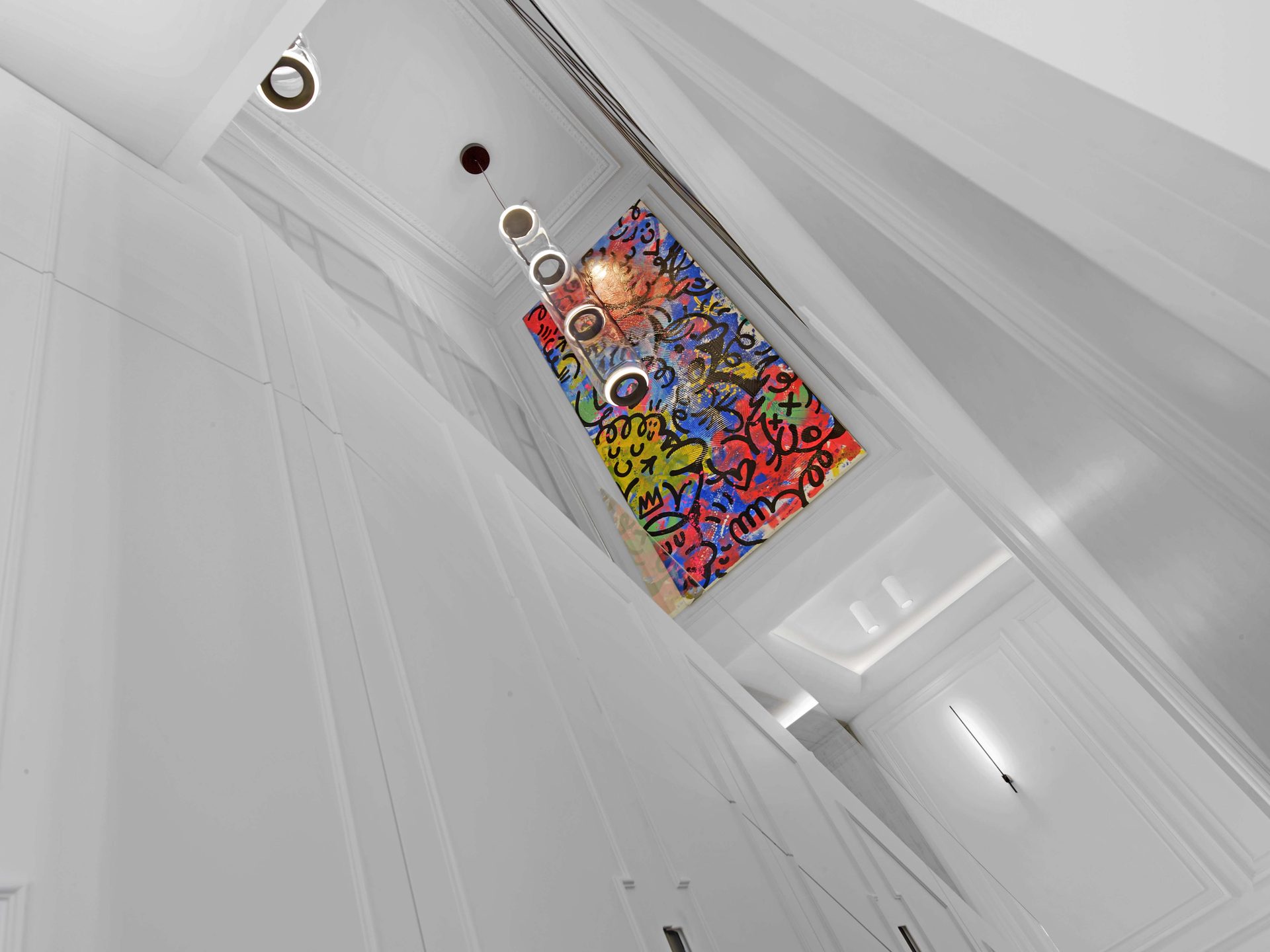 Pereire — vue 08 — plongée sur la cage d'escalier, suspension tubulaire en enfilade et toile colorée au mur