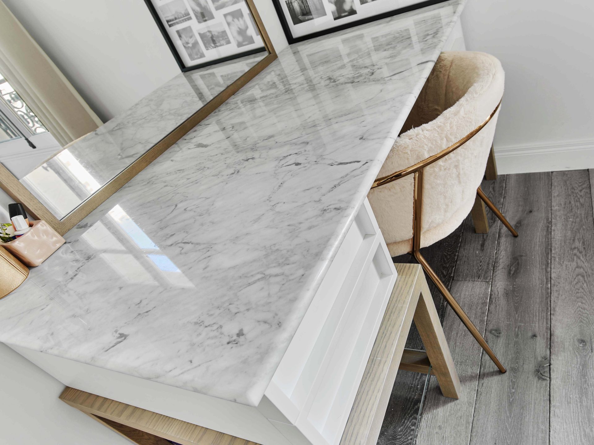 Pereire — vue 43 — détail en perspective du plateau de marbre du bureau, miroir à cadre chêne et fauteuil crème, séries de tirages noir et blanc encadrés