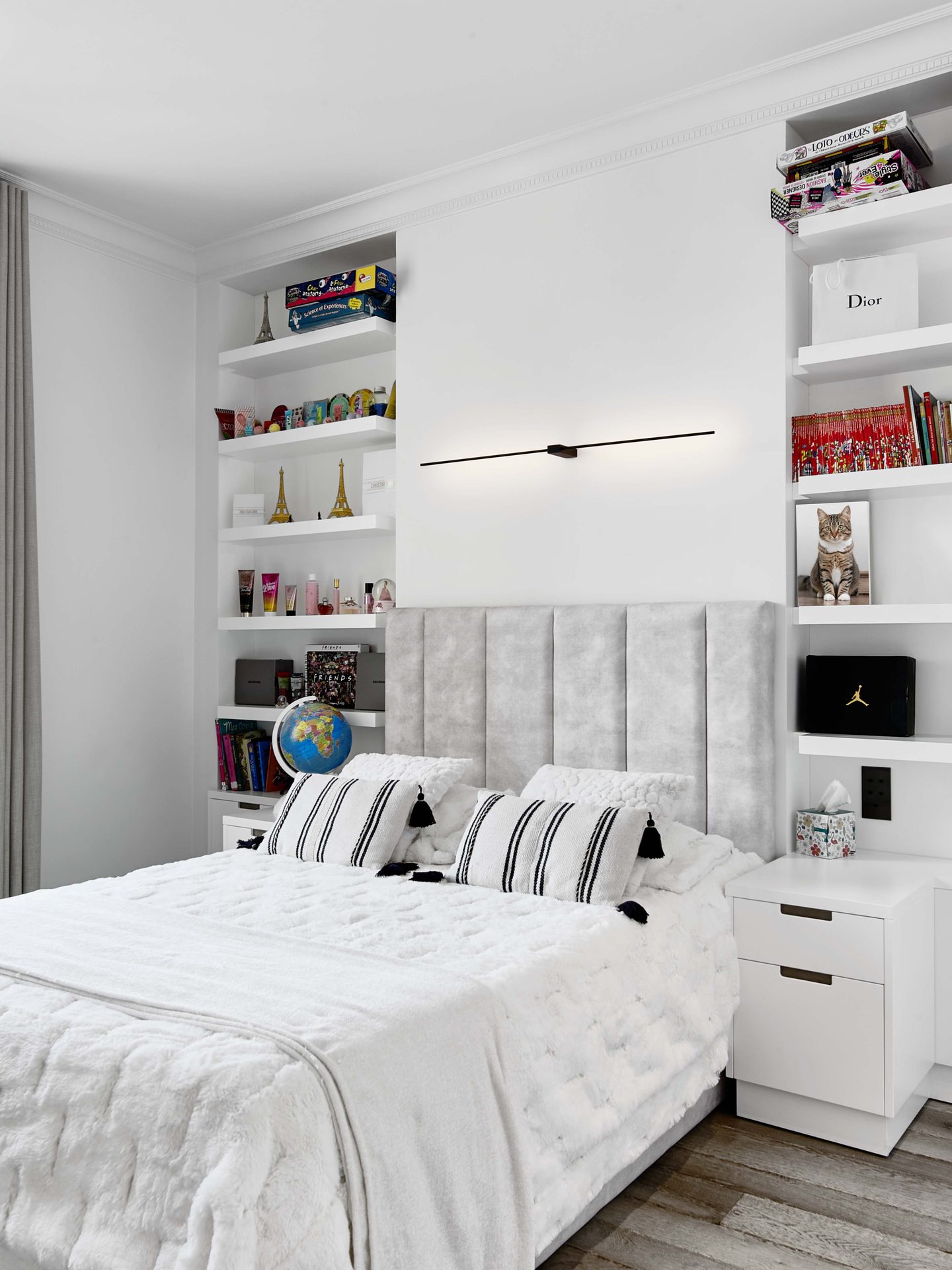 Pereire — vue 46 — chambre d'enfant, tête de lit capitonnée grise, étagères blanches garnies de livres et objets, parquet patiné
