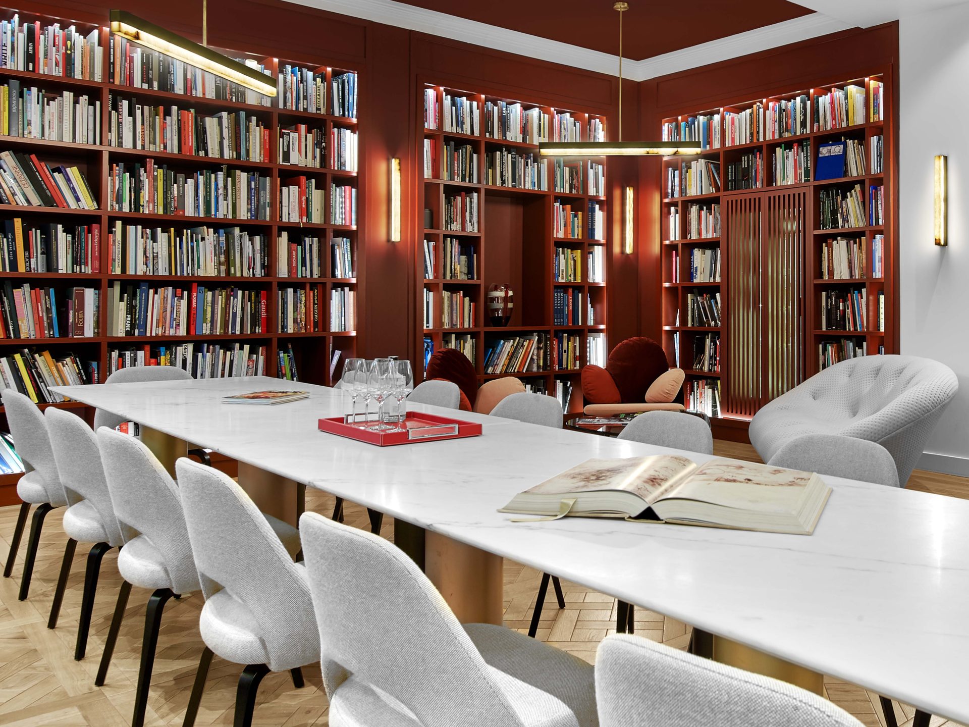 Beaux Arts — vue 62 — coin bibliothèque rouge, table de marbre, chaises grises et rayonnages
